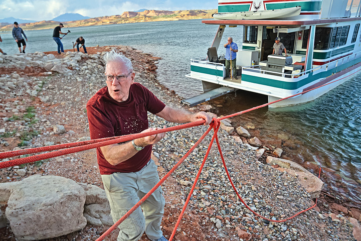 Larry Florence directs the boat’s mooring at a shoreside campsite. 